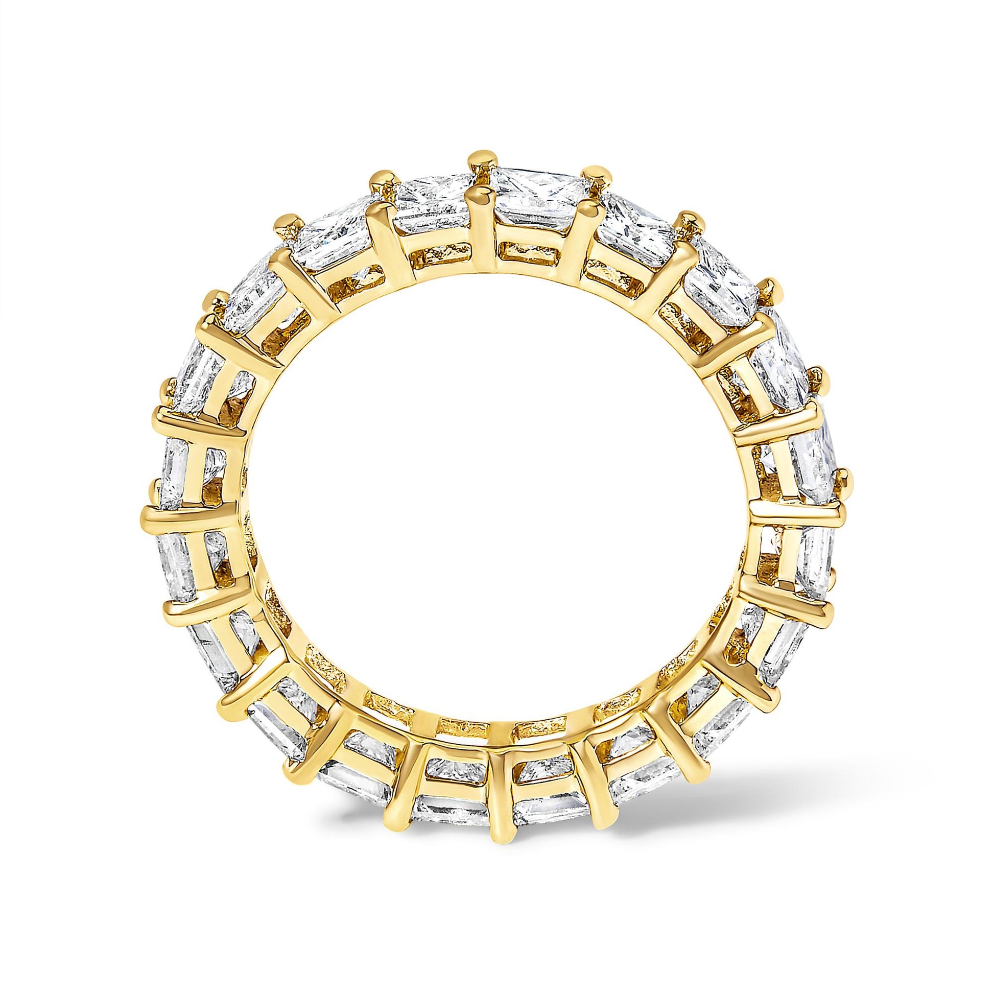 Yellow metal ring with princess-shaped white gemstones in prong settings, photographed from a front angle.