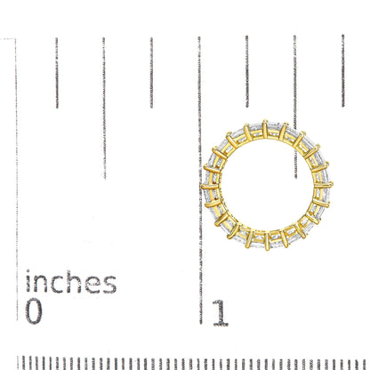 Top-down view of a yellow metal ring with white princess-shaped gemstones in a prong setting, placed on a ruler for size reference.