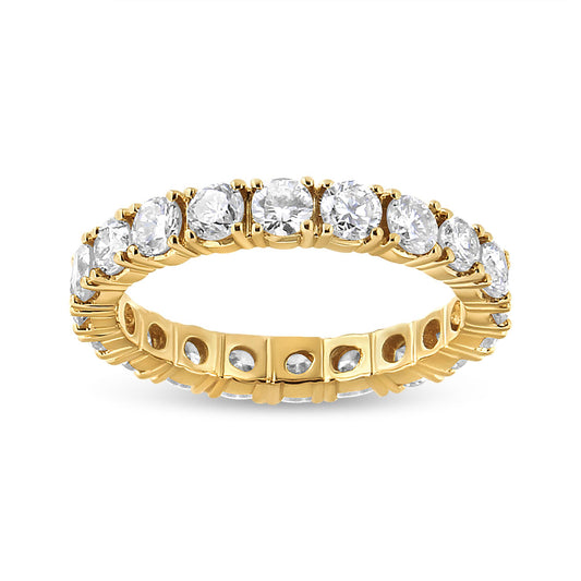 Yellow metal eternity ring with round white gemstones in prong settings, shown from a front angled view.