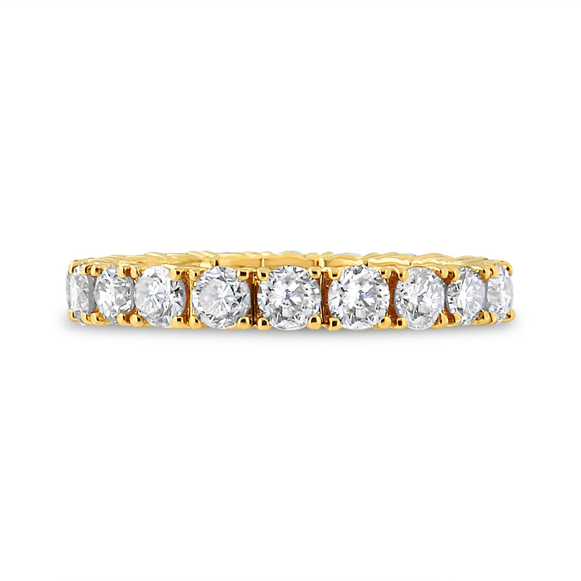 Close-up side view of a yellow metal ring featuring a row of round white gemstones in prong settings.