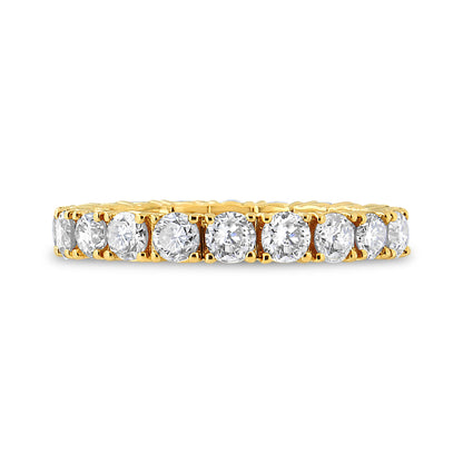 Close-up side view of a yellow metal ring featuring a row of round white gemstones in prong settings.