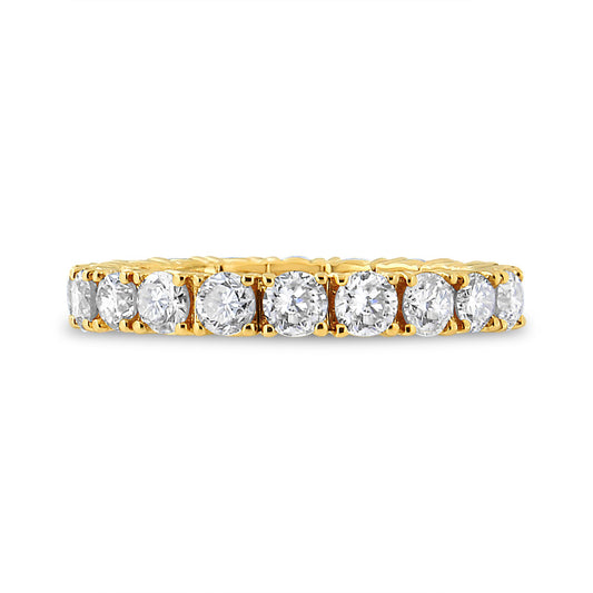 Close-up side view of a yellow metal ring featuring a row of round white gemstones in prong settings.