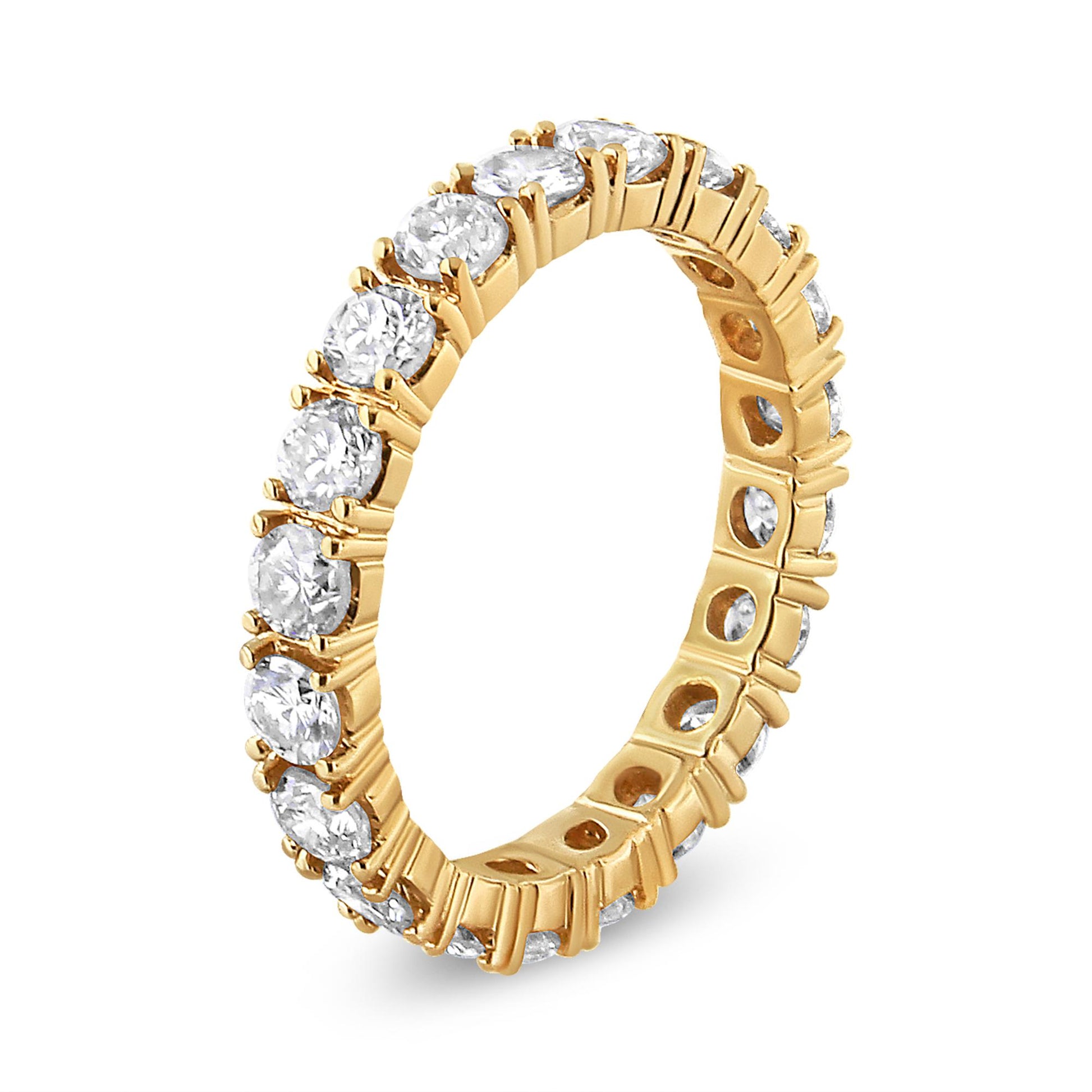 Angle shot of a yellow metal ring featuring round white gemstones in prong settings encircling the entire band.