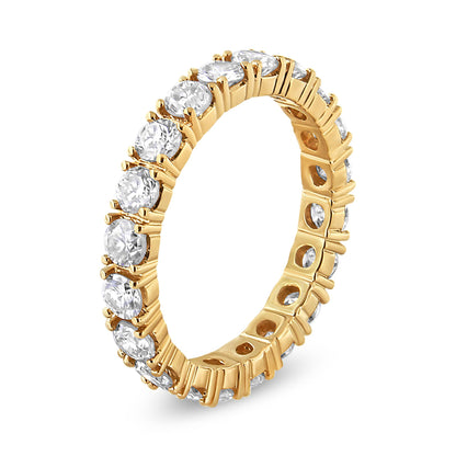 Angle shot of a yellow metal ring featuring round white gemstones in prong settings encircling the entire band.