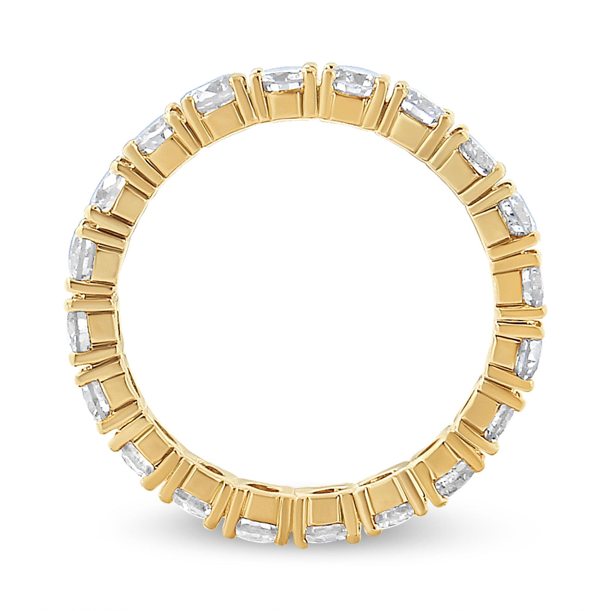Top-down view of a yellow metal ring with multiple round white gemstones in prong settings encircling the band.