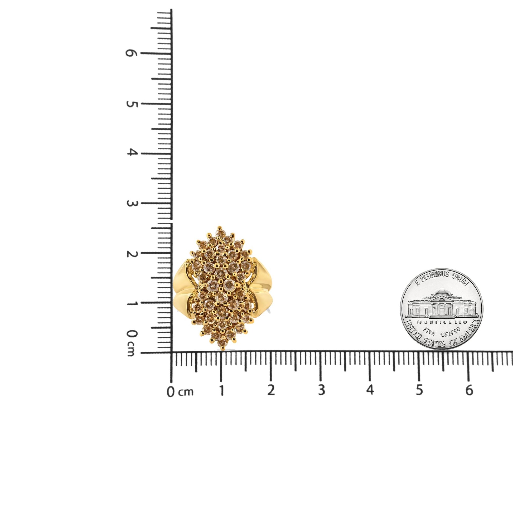 Top-down view of a yellow metal ring with multiple round champagne-colored gemstones in prong settings, placed on a ruler for size reference.