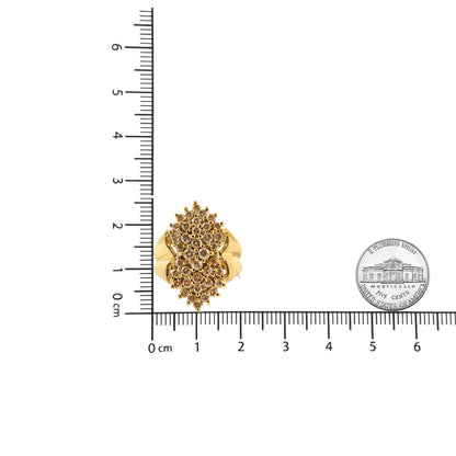 Top-down view of a yellow metal ring with multiple round champagne-colored gemstones in prong settings, placed on a ruler for size reference.