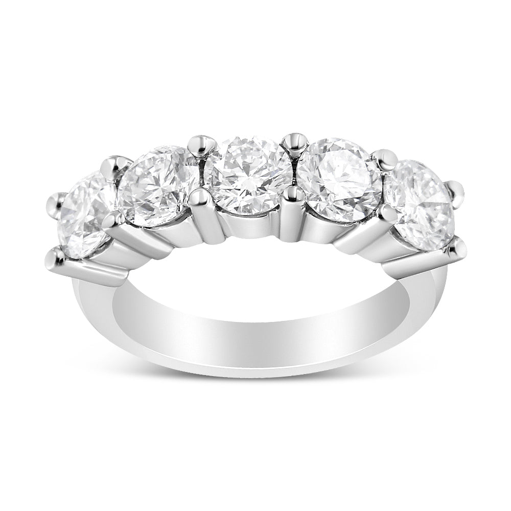 Front angled view of a white metal ring with five round white gemstones in a shared prong setting.