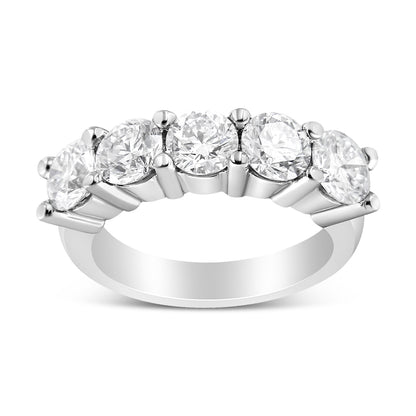 Front angled view of a white metal ring with five round white gemstones in a shared prong setting.