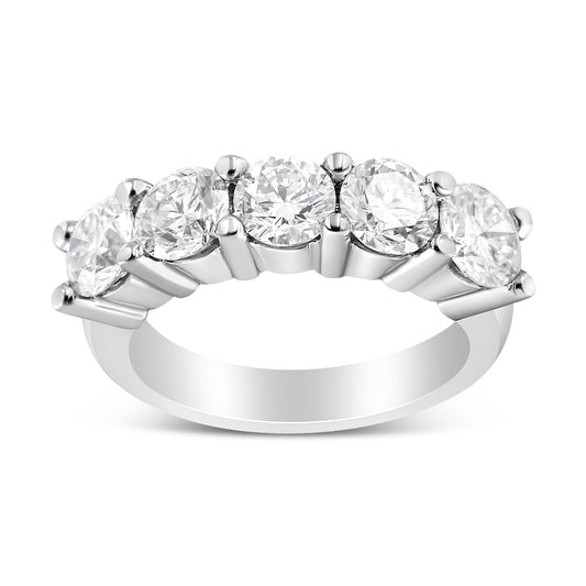 Front angled view of a white metal ring with five round white gemstones in a shared prong setting.