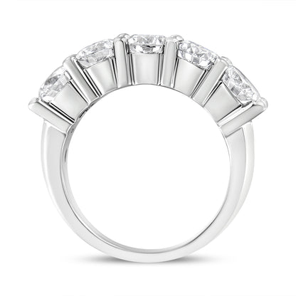 White metal ring with five round white gemstones in shared prong setting, shown from side angle.
