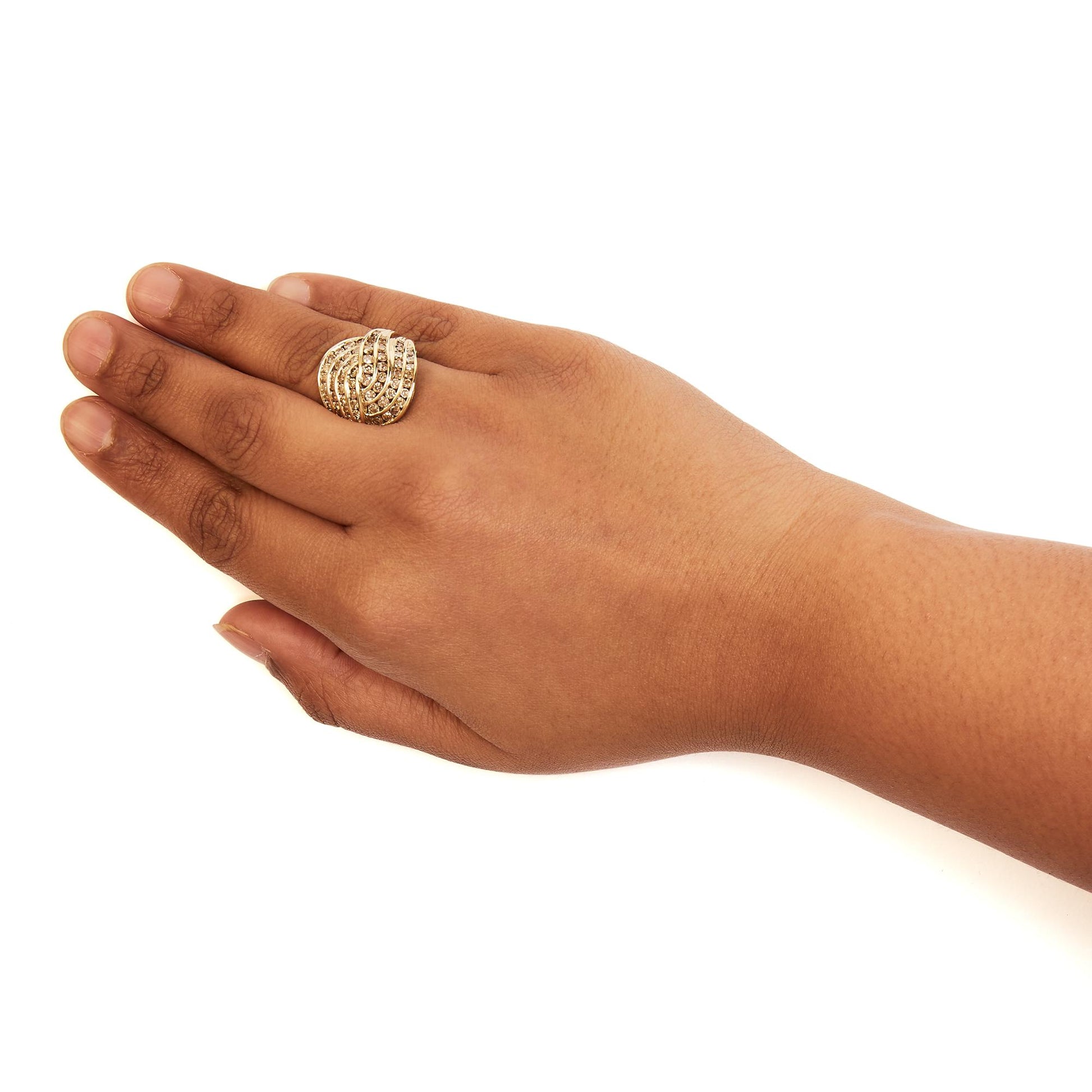 Close-up side angle of a yellow metal ring with multiple rows of brownish round gemstones in channel settings, worn on a model's hand.