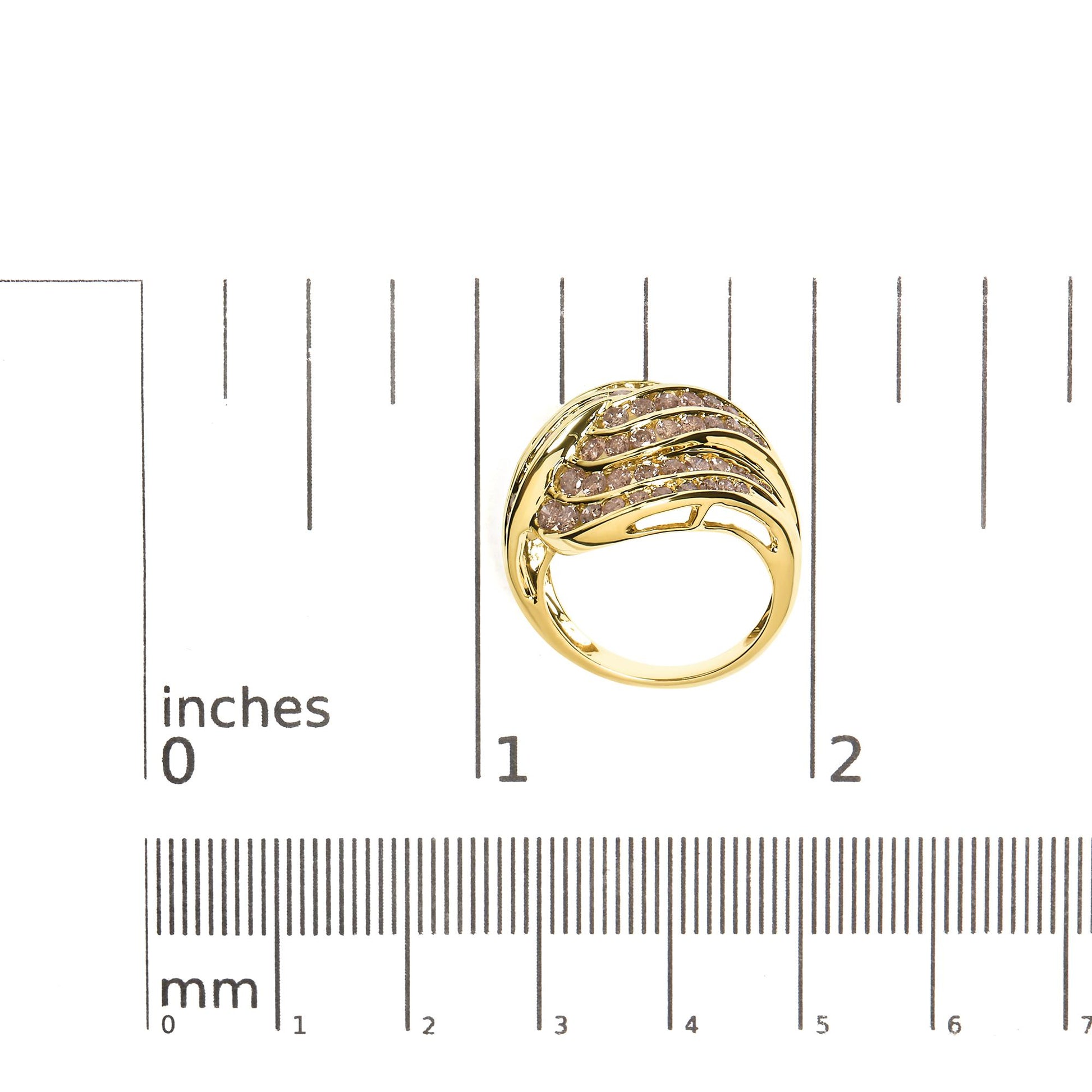 Top-down view of a yellow metal ring with multiple rows of channel-set round brownish gemstones, shown on a ruler for size reference.