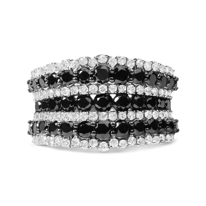 Close-up front angle of a white metal ring featuring alternating rows of round black and white gemstones in prong settings.