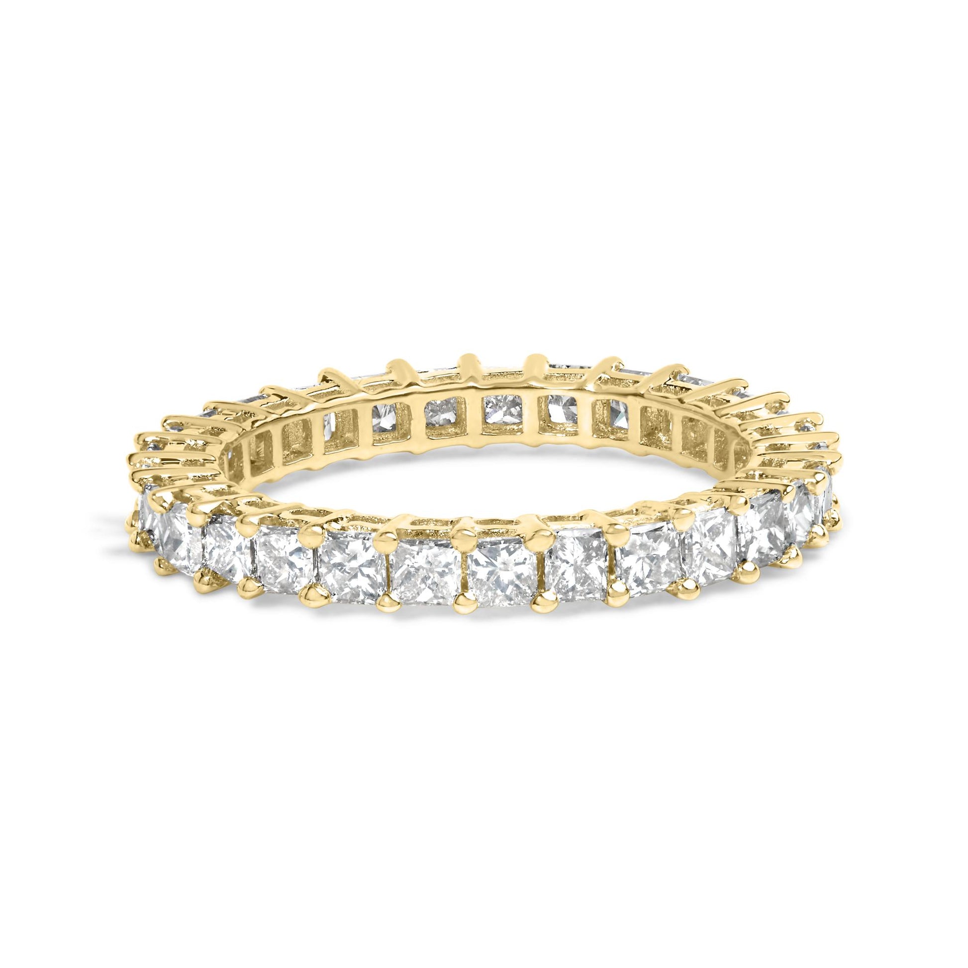 Yellow metal ring with princess-shaped white gemstones in a shared prong setting, shown in a close-up angled shot.