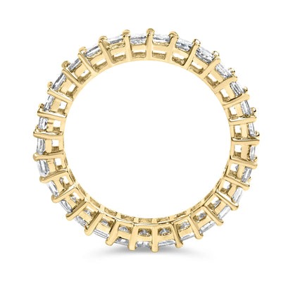 Top-down close-up of a yellow ring with white princess-shaped gemstones in a shared prong setting encircling the band.