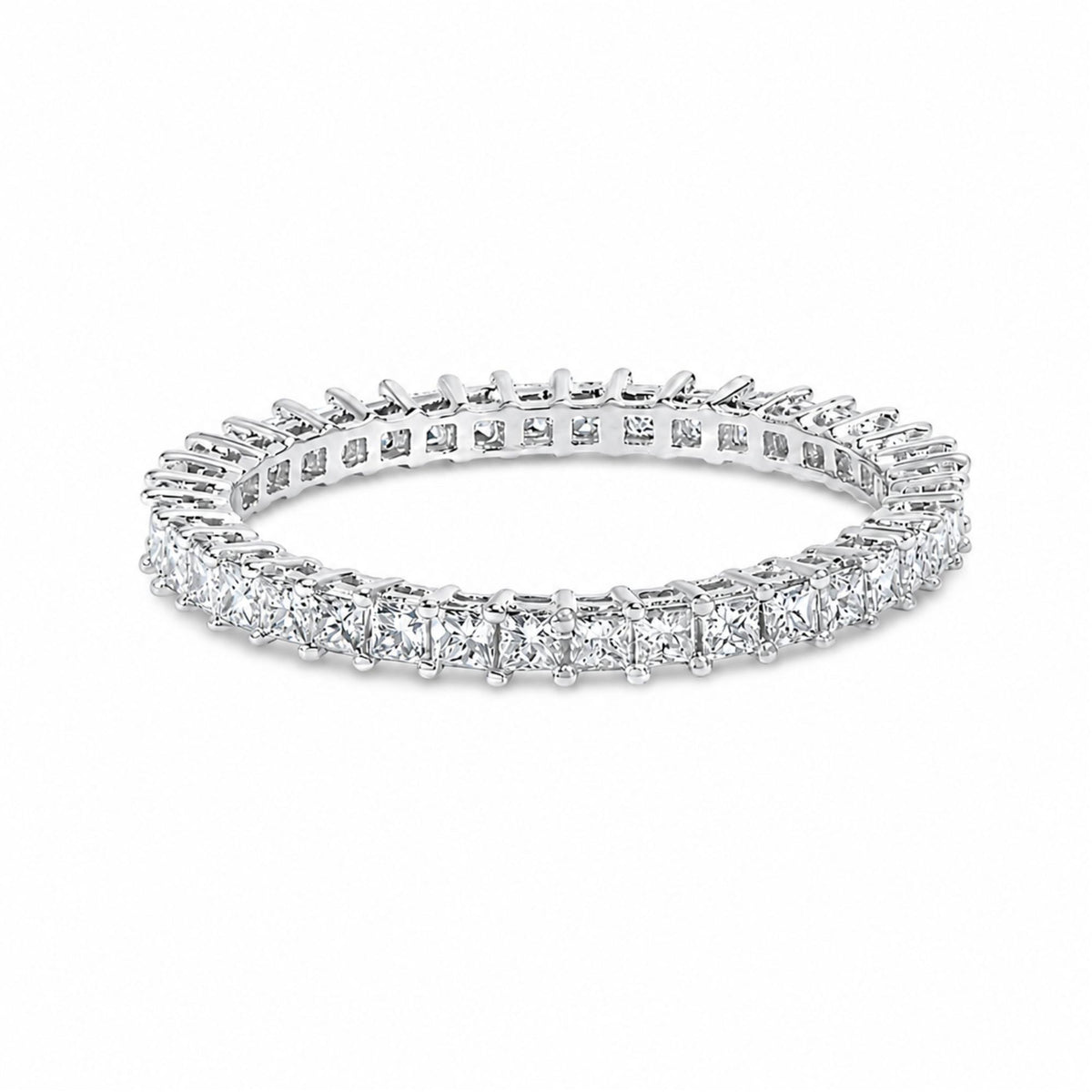 Close-up shot of a white ring featuring a continuous row of princess-shaped white gemstones in prong settings, shown on a white background.
