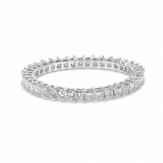 Close-up shot of a white ring featuring a continuous row of princess-shaped white gemstones in prong settings, shown on a white background.