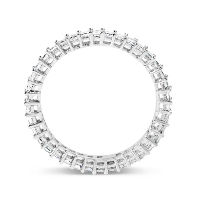 Close-up front view of a white ring featuring princess-shaped white gemstones in prong settings encircling the band, shown on a white background.