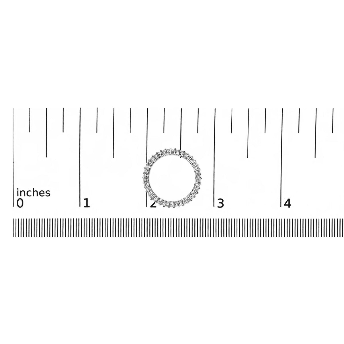 Top-down view of a white ring with a continuous row of princess-shaped white gemstones in prong settings, shown on a ruler scale.