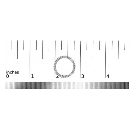 Top-down view of a white ring with a continuous row of princess-shaped white gemstones in prong settings, shown on a ruler scale.