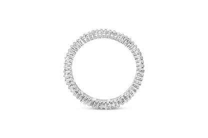 Top-down view of a white metal ring fully encircled with white princess-shaped gemstones in prong settings.