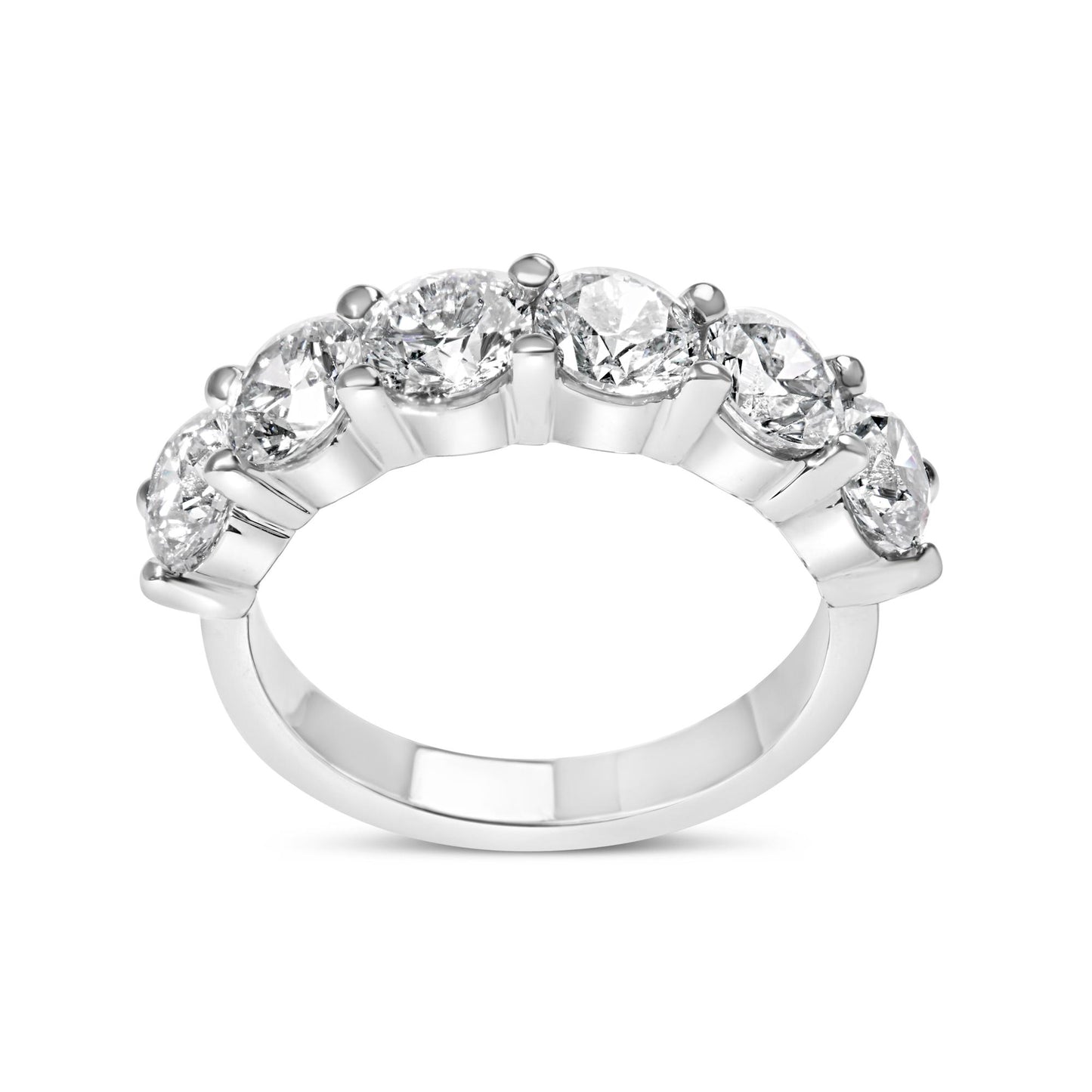 White metal ring with six round white gemstones in shared prong setting, side angle view.