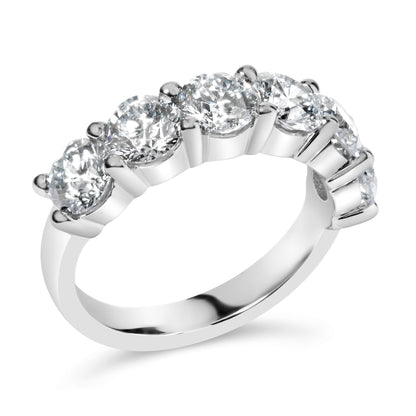 White metal ring with a row of round white gemstones in shared prong settings, shown at a slight angle.