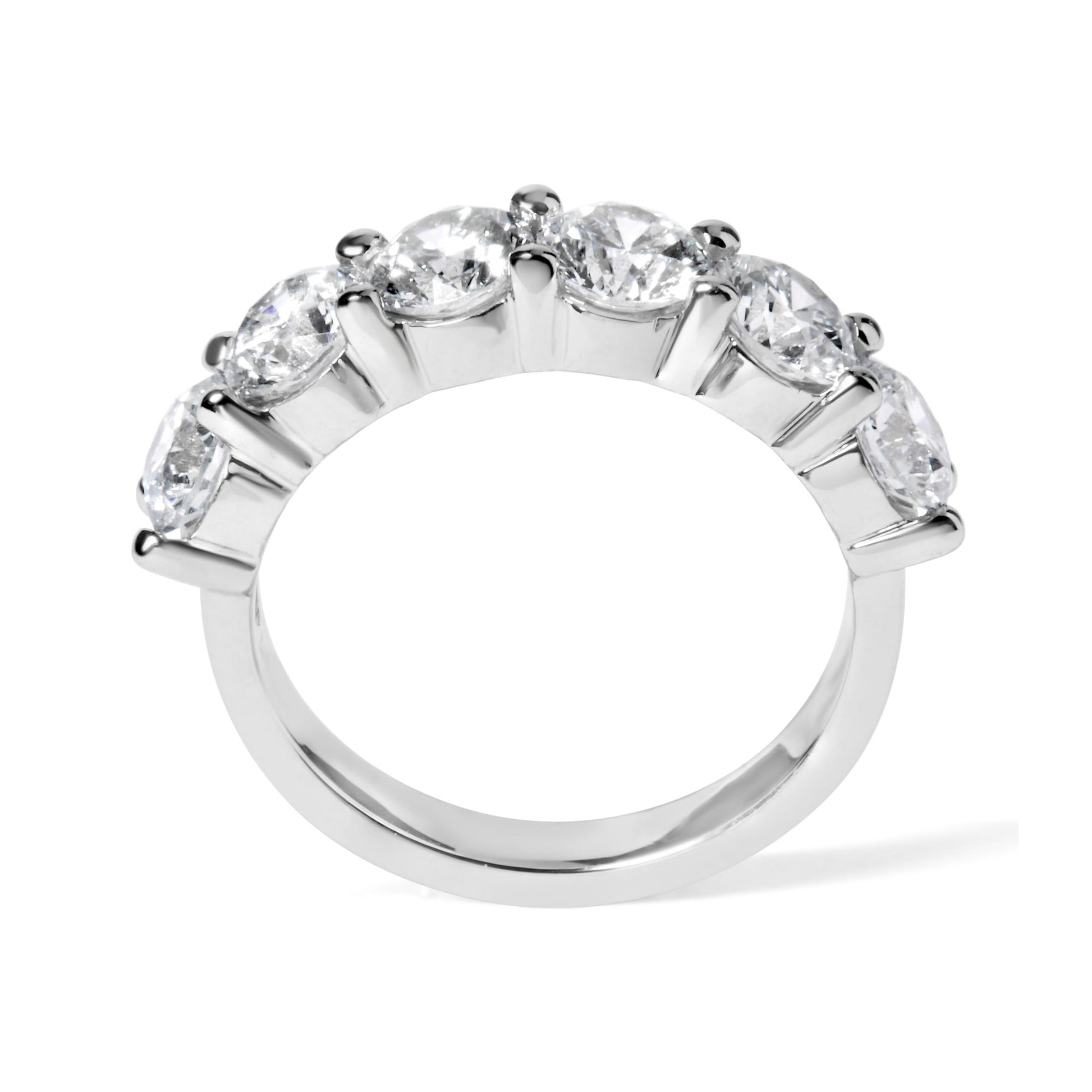 Close-up front angle of a white ring featuring a row of six round white gemstones in a shared prong setting.