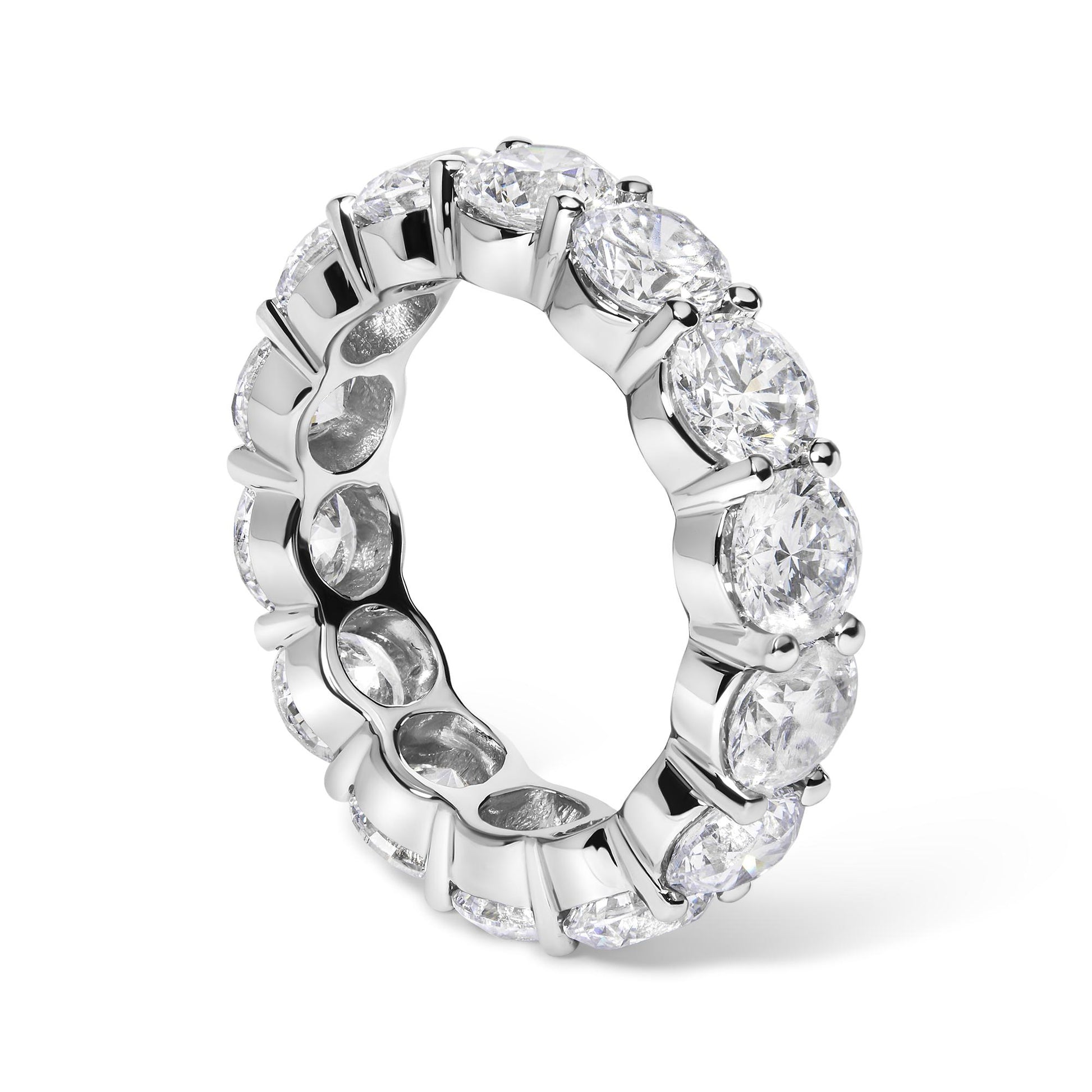 White metal eternity ring with round white gemstones in shared prong setting, shown at a slight angle.
