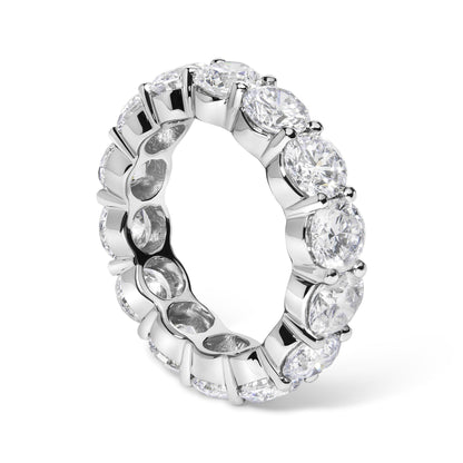 White metal eternity ring with round white gemstones in shared prong setting, shown at a slight angle.
