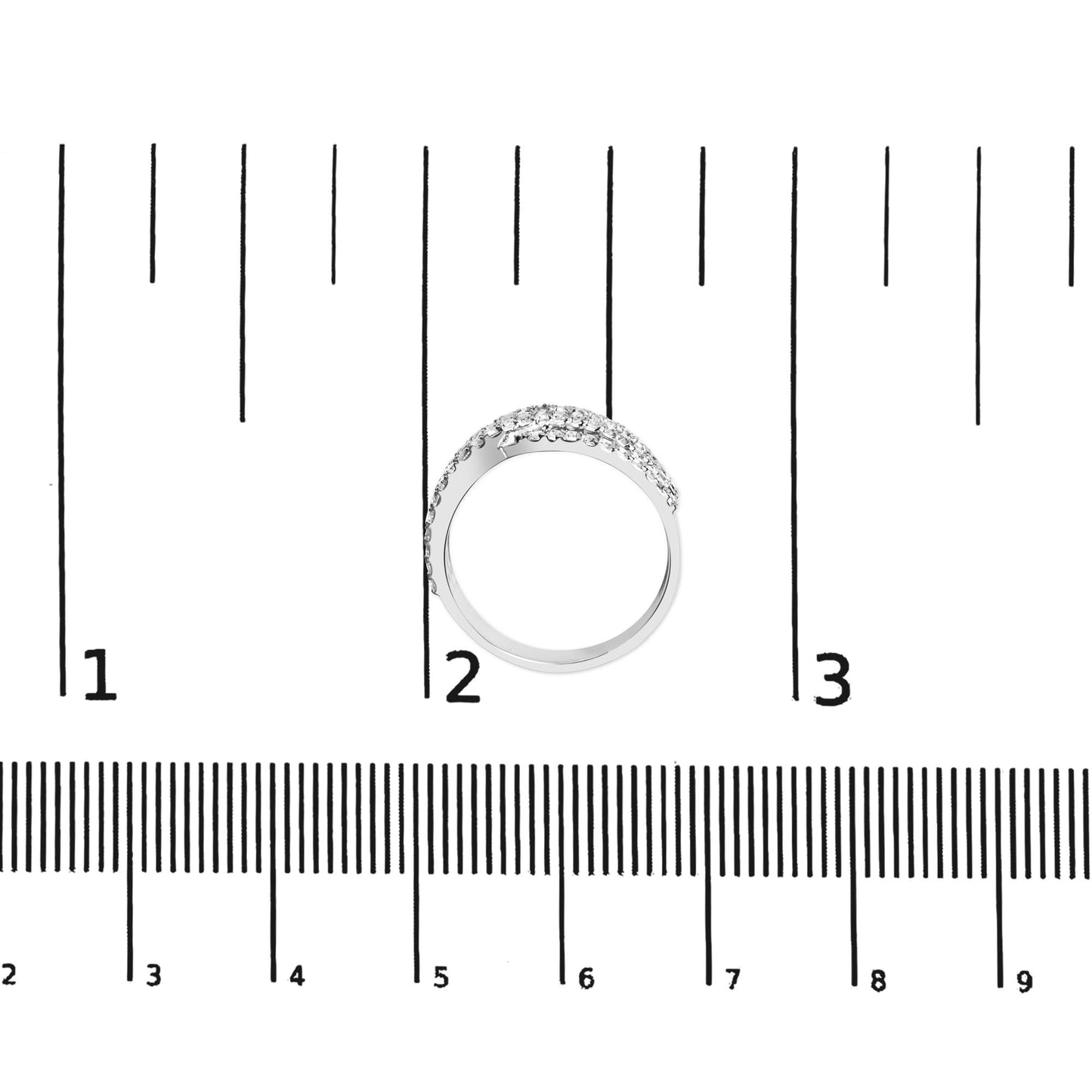 Top view of white metal ring with multiple rows of prong-set white princess-shaped gemstones, placed on a ruler for size reference.