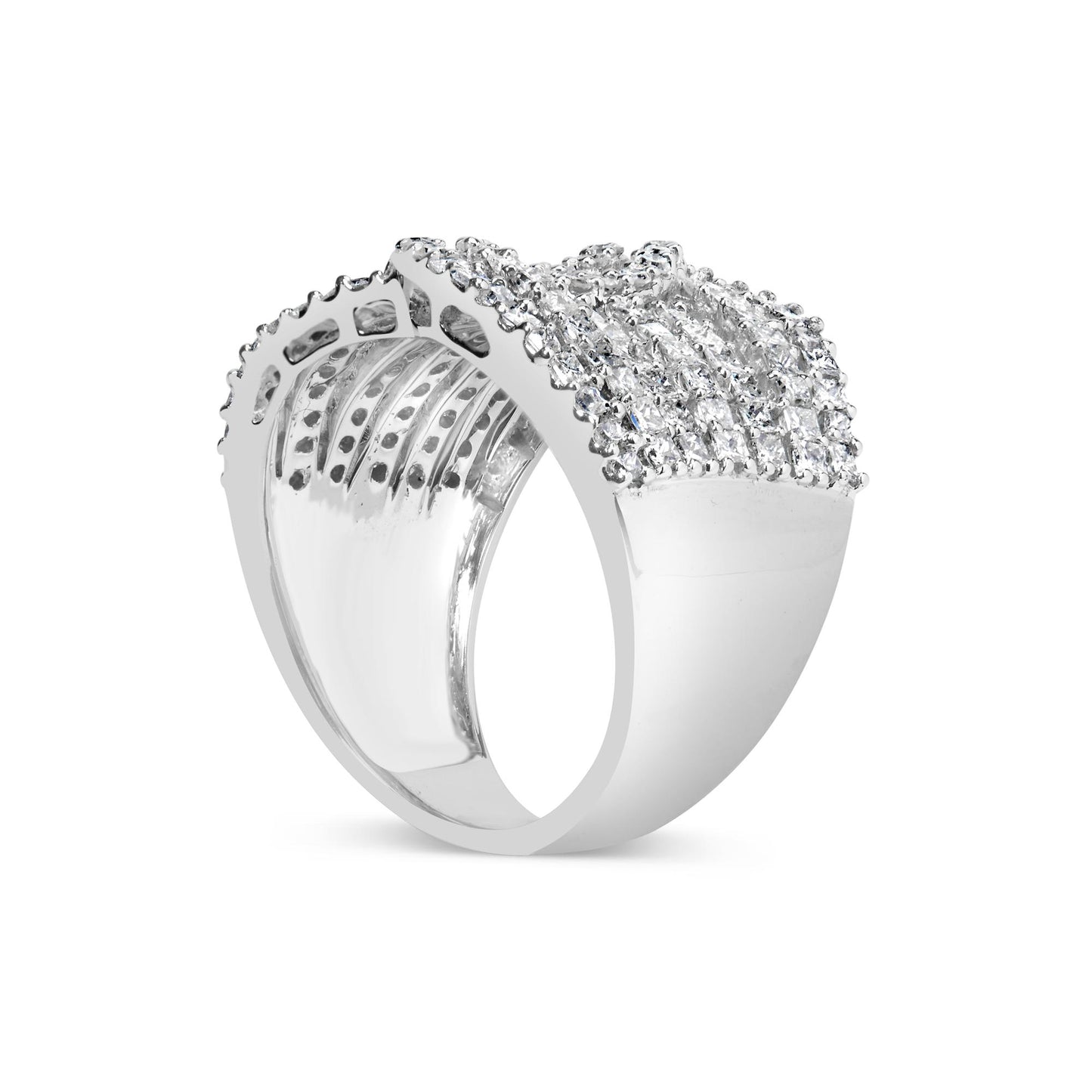 White metal ring viewed from an angled side showing a wide band encrusted with rows of small princess-shaped gemstones in an invisible setting and round gemstones in prong settings on top.