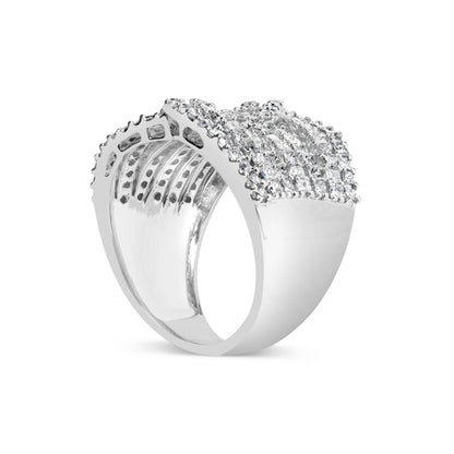 White metal ring viewed from an angled side showing a wide band encrusted with rows of small princess-shaped gemstones in an invisible setting and round gemstones in prong settings on top.
