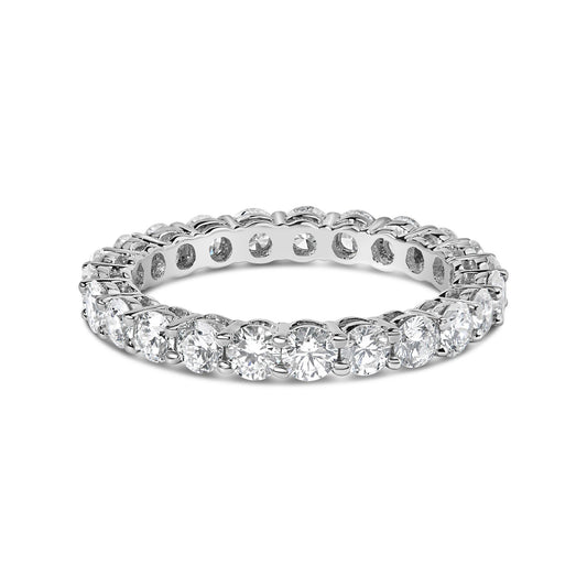 White metal eternity ring with round white gemstones in a shared prong setting, shown in a close-up angled view.