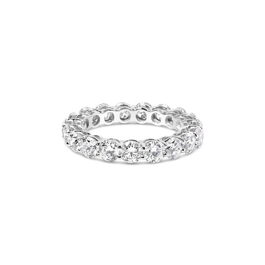White metal eternity ring with round white gemstones in prong settings viewed from a front angle on a white background.