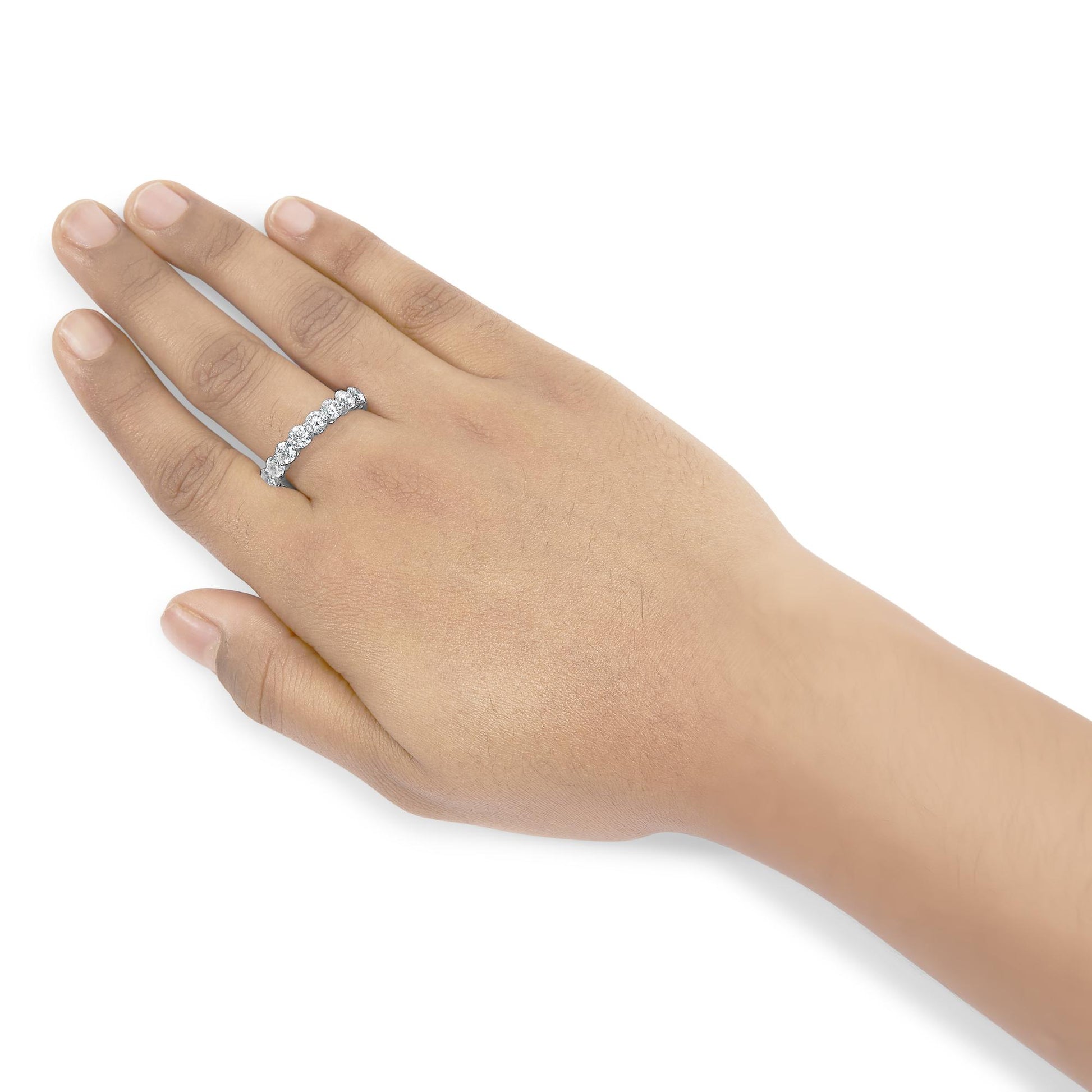 White metal ring with round prong-set white gemstones, shown on a model's hand from a top angle.