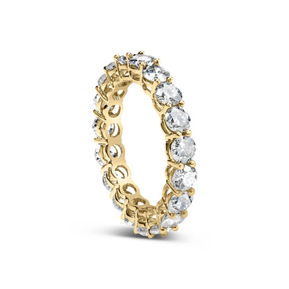Yellow ring with round white gemstones in shared prong setting, shown in a floating close-up angled view.