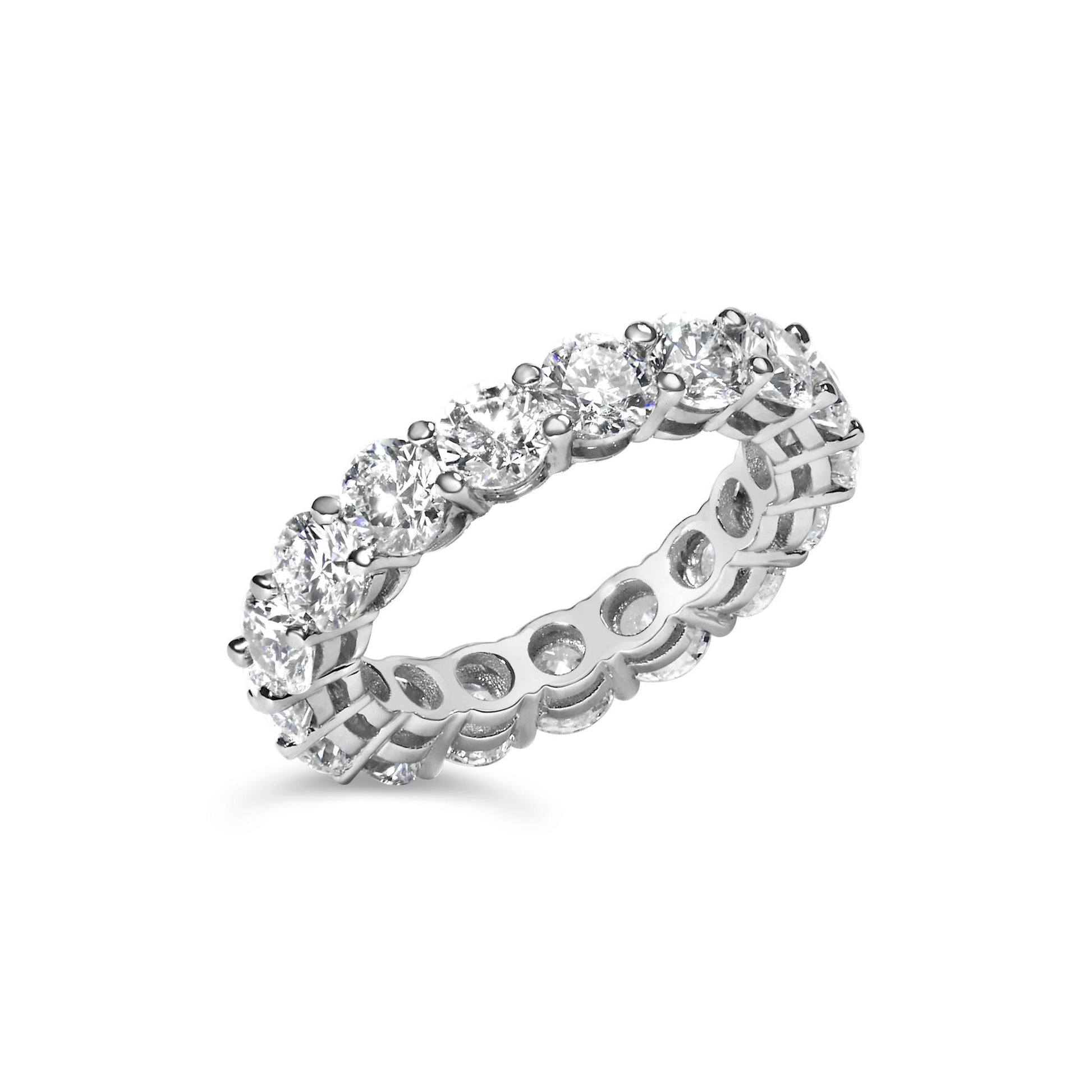 White metal eternity band ring with round white gemstones in shared prong setting, shown at a slight angle on a white background.