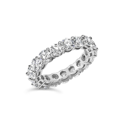 White metal eternity band ring with round white gemstones in shared prong setting, shown at a slight angle on a white background.