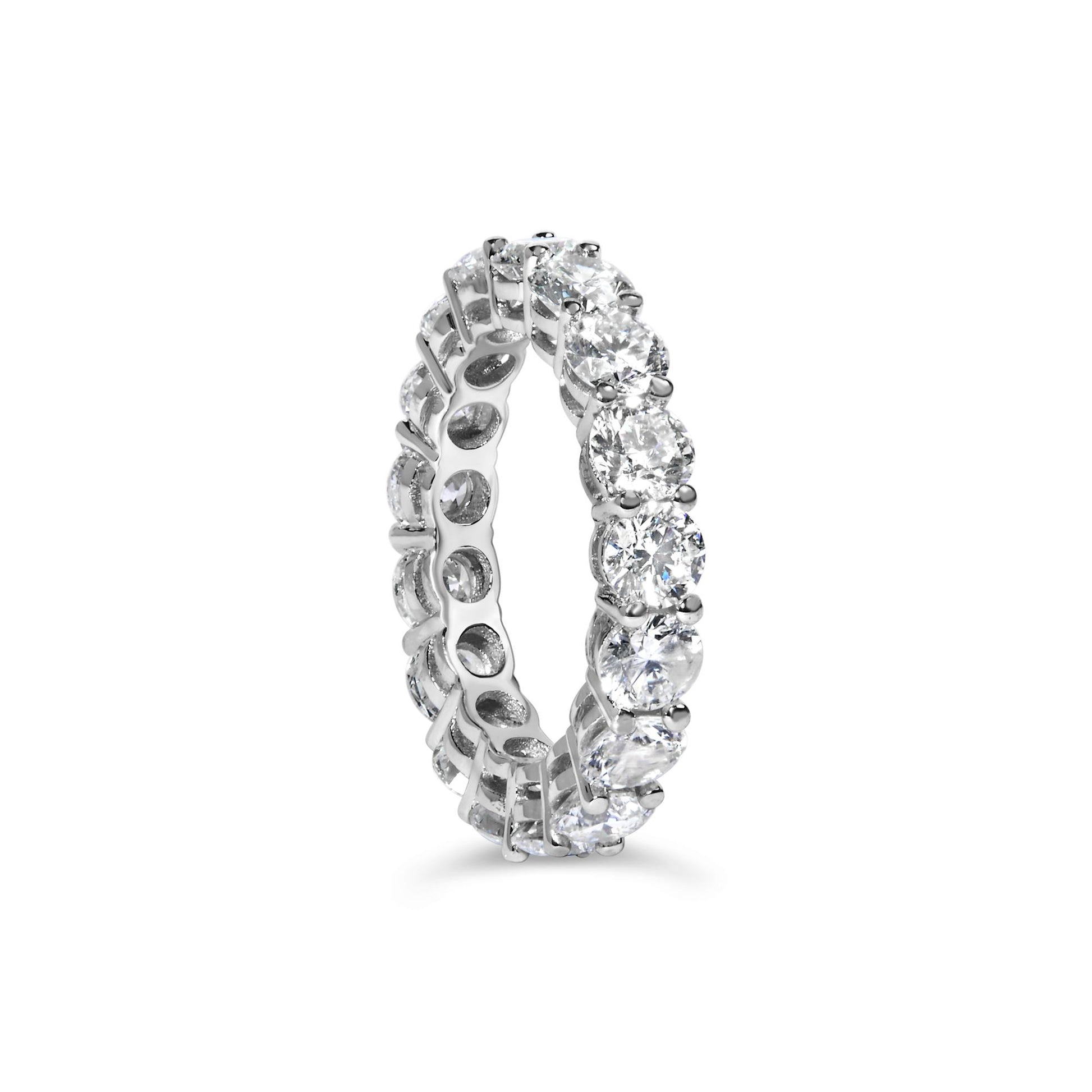 Close-up front angle of a white metal eternity ring featuring a continuous row of round white gemstones in a shared prong setting.
