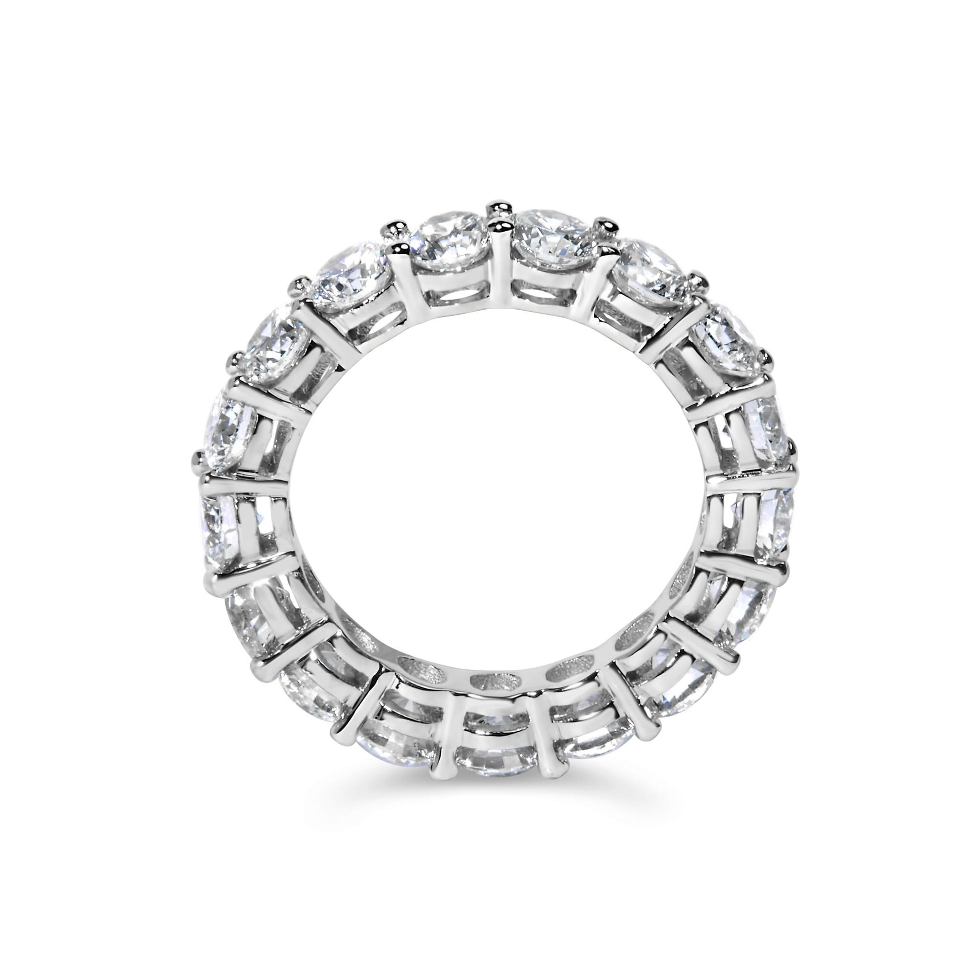 Top-down view of a white metal ring set with round white gemstones in a shared prong setting encircling the band.