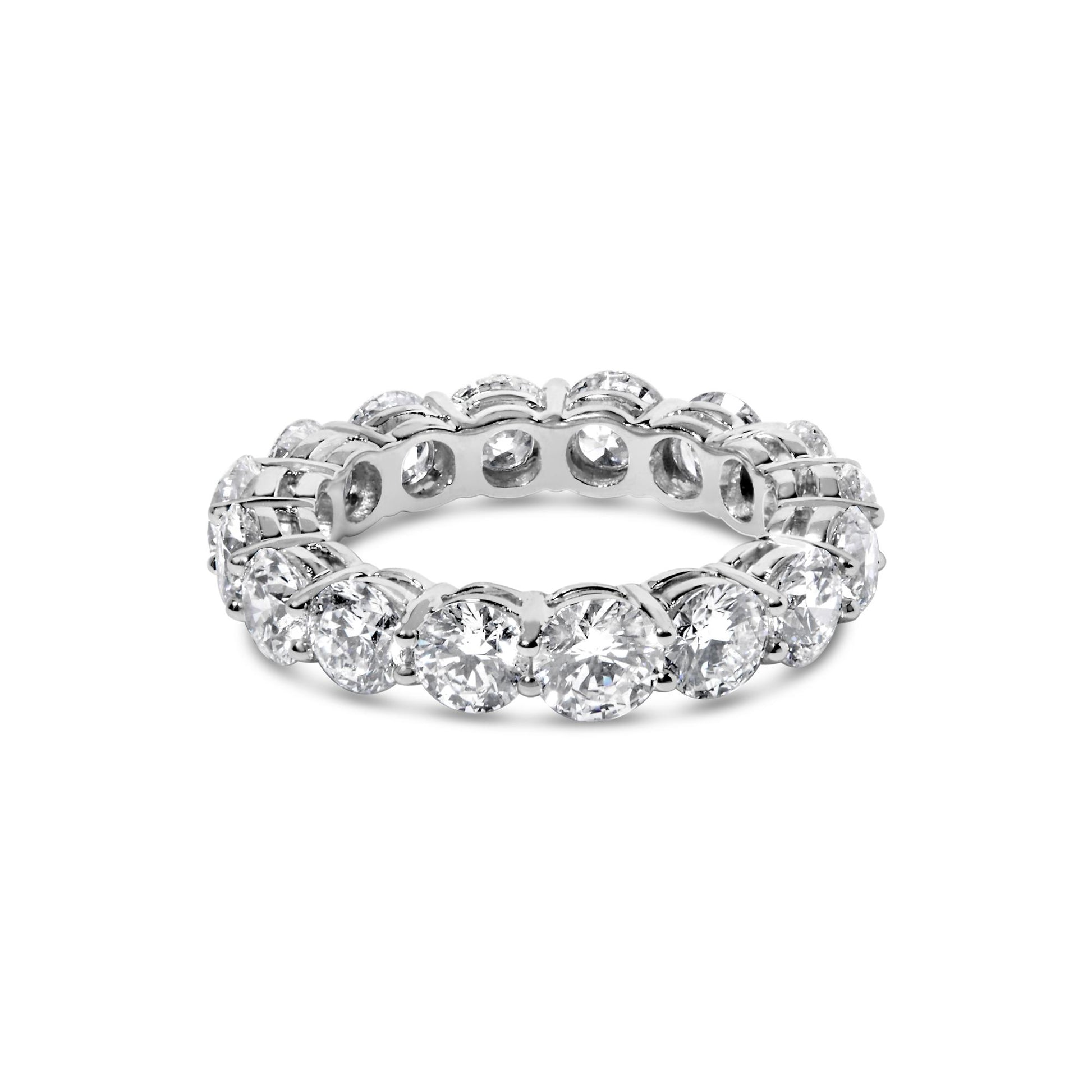 White metal ring with round white gemstones in prong settings all around, shown from a slightly elevated front angle.