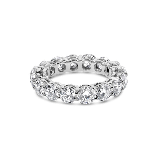 White metal ring with round white gemstones in prong settings all around, shown from a slightly elevated front angle.