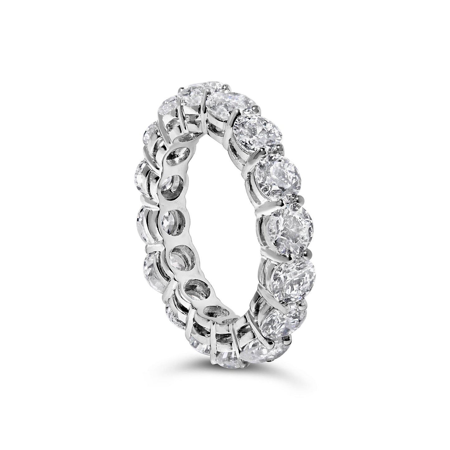 White metal eternity ring with round white gemstones in prong settings, shown at an angled close-up.