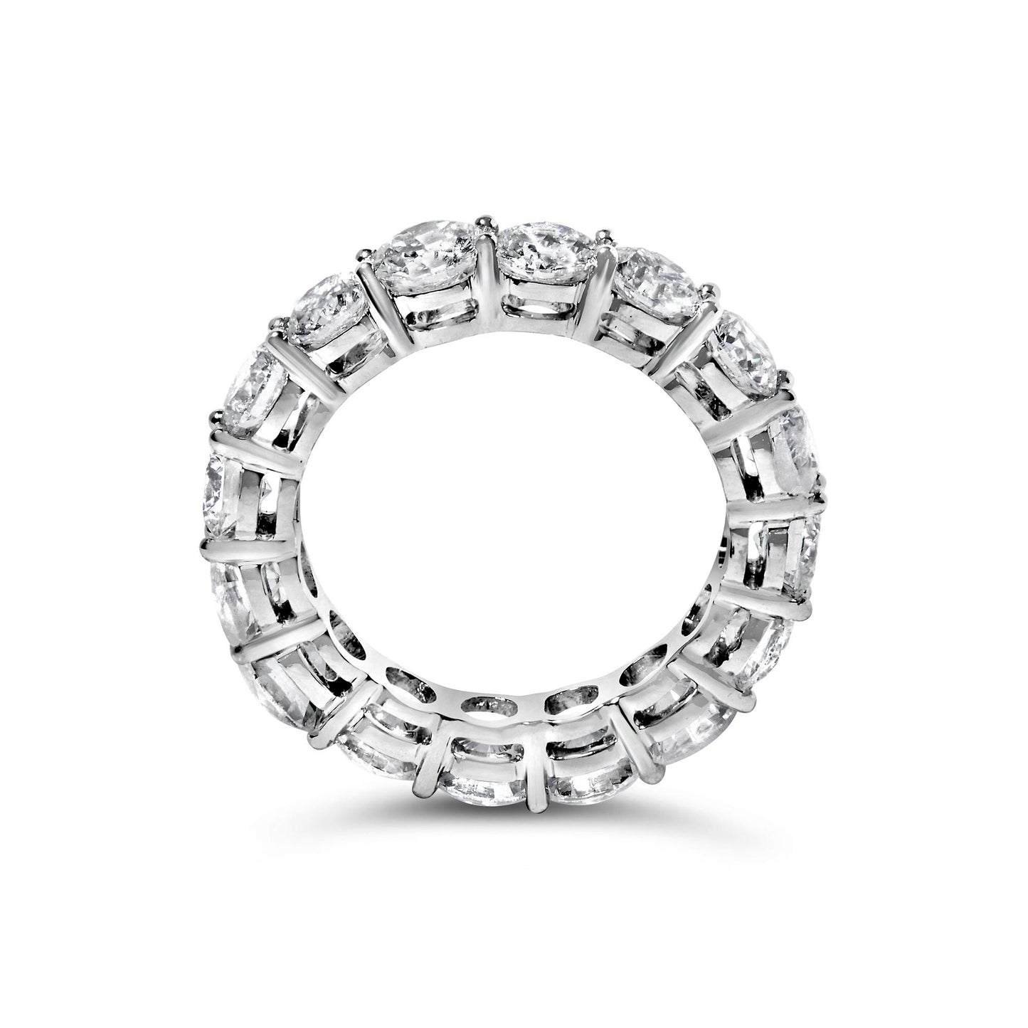 Top-down view of a white metal eternity ring with round white gemstones in prong settings encircling the entire band.