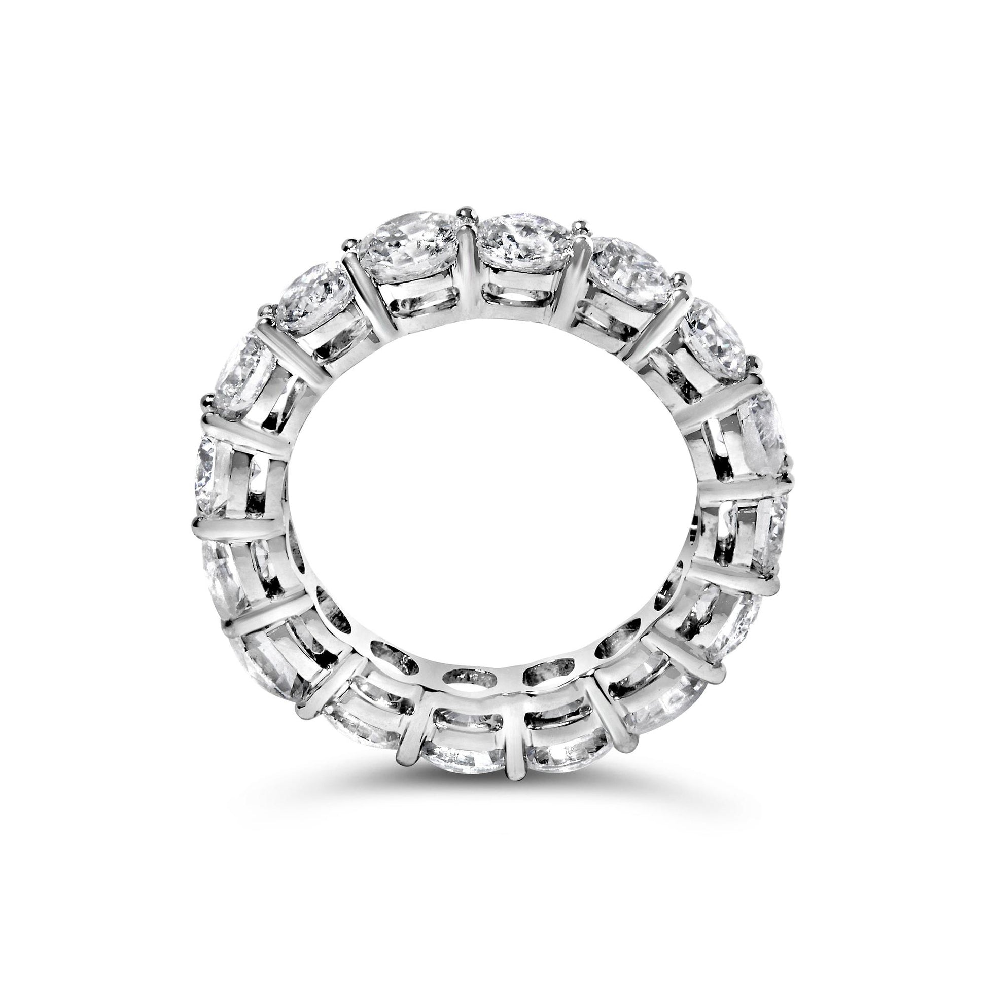 Top-down view of a white metal eternity ring with round white gemstones in prong settings encircling the entire band.