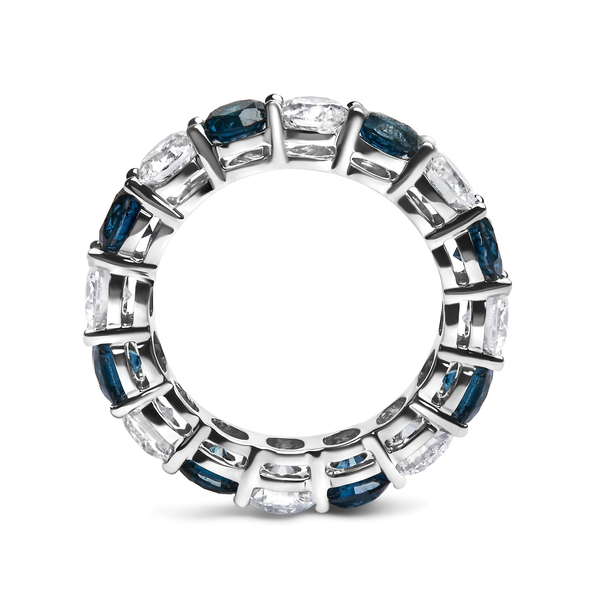 Top-down close-up of a white ring featuring alternating round blue and white gemstones in a shared prong setting.