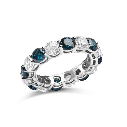 White metal eternity ring with alternating round blue and white gemstones in shared prong settings, shown in a close-up angled view.