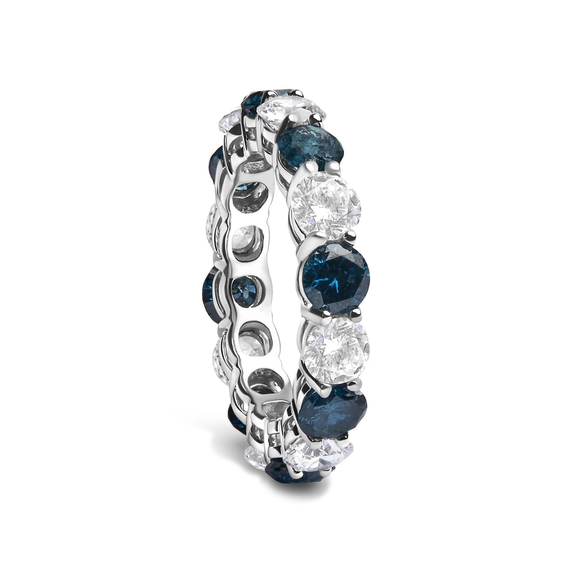Close-up front angle view of a white metal ring featuring alternating round blue and white gemstones in a shared prong setting encircling the band.